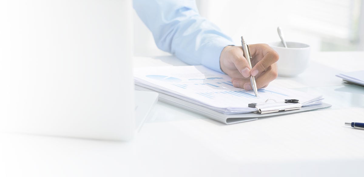 Business Man with laptop and stack of reports