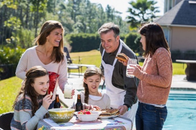 Family enjoying backyard cookout eating hamburgers-1