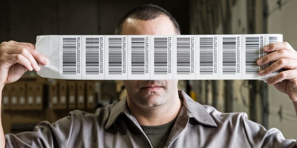 a-warehouse-worker-holding-up-a-sheet-of-bar-code-2023-11-27-05-23-26-utc
