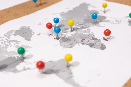 close-up-of-pushpins-on-world-map-on-corkboard-2023-11-27-05-22-29-utc