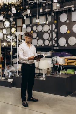 man-browsing-catalog-in-a-lighting-store-showroom-2025-08-27-10-39-43-utc