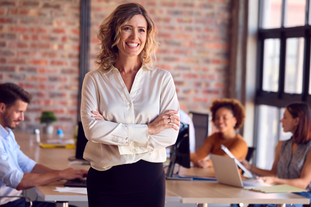 portrait-of-smiling-businesswoman-standing-in-busy-office