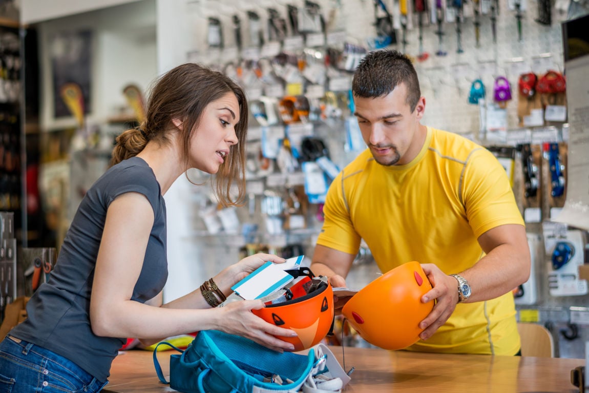 Woman buying canyoning equipment in sports store