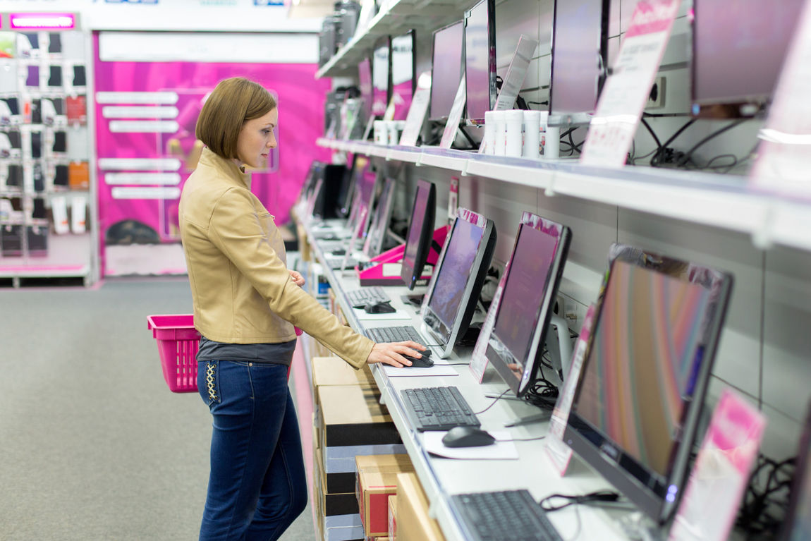 woman buying desktop in store